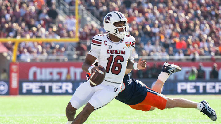 Dec 31, 2024; Orlando, FL, USA; South Carolina Gamecocks quarterback LaNorris Sellers (16) runs the ball against Illinois Fighting Illini linebacker Joe Barna (43) in the first quarter at Camping World Stadium. Mandatory Credit: Jeremy Reper-Imagn Images