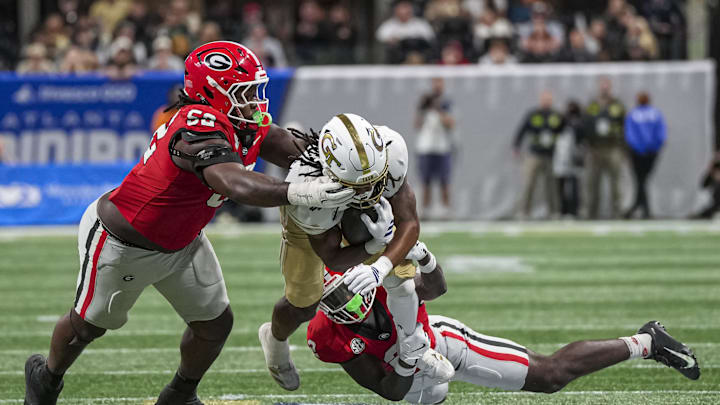 Nov 28, 2025; Atlanta, Georgia, USA; Georgia Tech Yellow Jackets running back Chad Alexander (27) is tackled by Georgia Bulldogs defensive lineman Christen Miller (52) and safety Zion Branch (2) during the second half at Mercedes-Benz Stadium. Mandatory Credit: Dale Zanine-Imagn Images