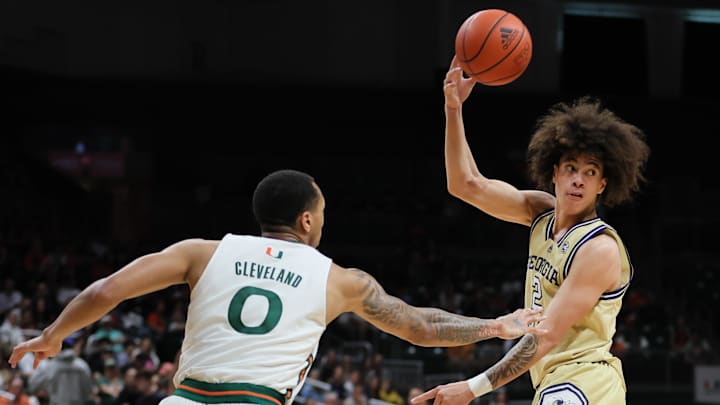 Feb 24, 2024; Coral Gables, Florida, USA; Georgia Tech Yellow Jackets guard Naithan George (2) passes the basketball as Miami Hurricanes guard Matthew Cleveland (0) defends during the first half at Watsco Center. Mandatory Credit: Sam Navarro-Imagn Images