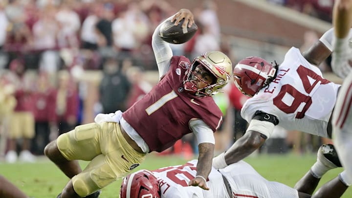 Aug 30, 2025; Tallahassee, Florida, USA; Florida State Seminoles quarterback Tommy Castellanos (1) loses his footing against Alabama Crimson Tide linebacker Jah-Marien Latham (20) during the second half at Doak S. Campbell Stadium. Mandatory Credit: Melina Myers-Imagn Images