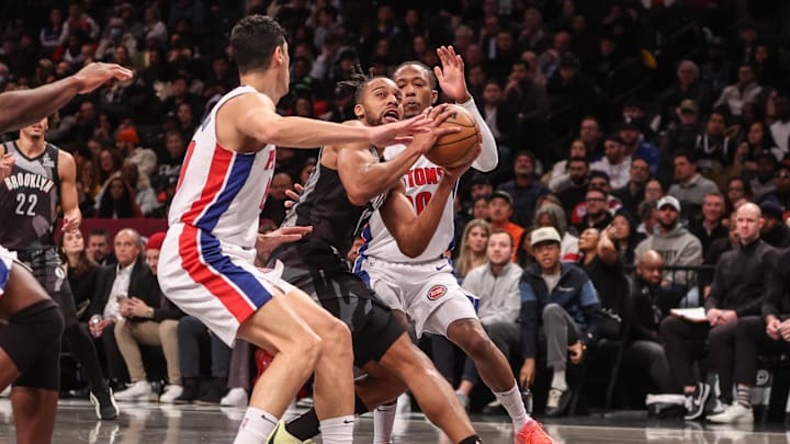 Jan 8, 2025; Brooklyn, New York, USA;  Brooklyn Nets forward Tosan Evbuomwan (12) looks to drive past Detroit Pistons forward Simone Fontecchio (19) in the third quarter at Barclays Center. Mandatory Credit: Wendell Cruz-Imagn Images