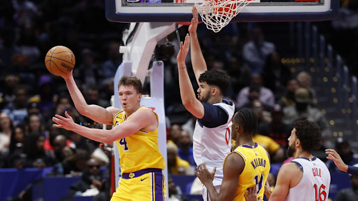 Jan 30, 2025; Washington, District of Columbia, USA; Los Angeles Lakers guard Dalton Knecht (4) passes the ball as Washington Wizards forward Tristan Vukcevic (00) defends in the fourth quarter at Capital One Arena. Mandatory Credit: Geoff Burke-Imagn Images