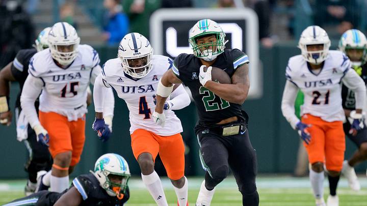 Nov 24, 2023; New Orleans, Louisiana, USA; Tulane Green Wave running back Makhi Hughes (21) runs against UTSA Roadrunners running back Kevorian Barnes (4) during the first half at Yulman Stadium. Mandatory Credit: Matthew Hinton-USA TODAY Sports Nov 24, 2023; New Orleans, Louisiana, USA; Tulane Green Wave running back Makhi Hughes (21) runs against UTSA Roadrunners running back Kevorian Barnes (4) during the first half at Yulman Stadium. Mandatory Credit: Matthew Hinton-USA TODAY Sports