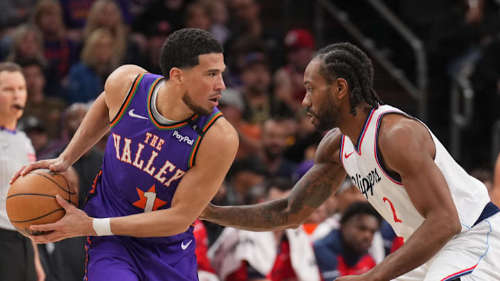 Mar 4, 2025; Phoenix, Arizona, USA; LA Clippers forward Kawhi Leonard (2) guards Phoenix Suns guard Devin Booker (1) during the first half at PHX Center. Mandatory Credit: Joe Camporeale-Imagn Images