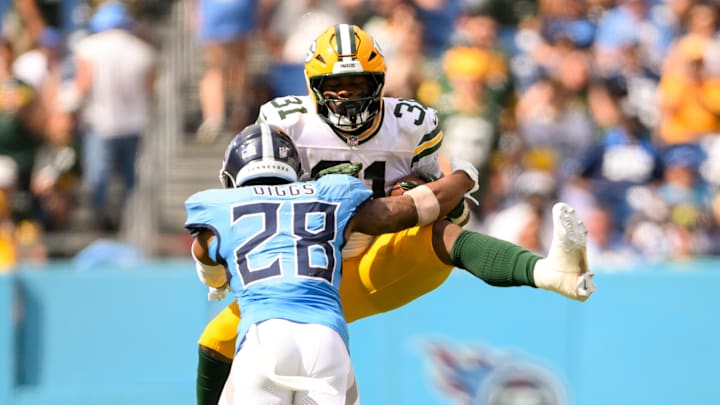Sep 22, 2024; Nashville, Tennessee, USA;  Tennessee Titans safety Quandre Diggs (28) hits Green Bay Packers running back Emanuel Wilson (31) in the air during the second half at Nissan Stadium. Mandatory Credit: Steve Roberts-Imagn Images