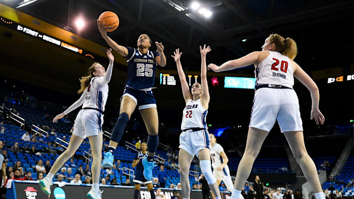Mar 21, 2025; Los Angeles, California, USA; Richmond Spiders guard Katie Hill (25) drives to the basket between Richmond Spiders forward Maggie Doogan (44) and Richmond Spiders guard Rachel Ullstrom (22) during the first quarter of an NCAA Tournament first-round game at Pauley Pavilion presented by Wescom. Mandatory Credit: Robert Hanashiro-Imagn Images