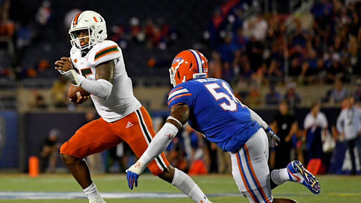 Aug 24, 2019; Orlando, FL, USA; Miami Hurricanes quarterback Jarren Williams (15) scramble with the ball around Florida Gators linebacker Ventrell Miller (51) during the first half at Camping World Stadium. Mandatory Credit: Jasen Vinlove-USA TODAY Sports