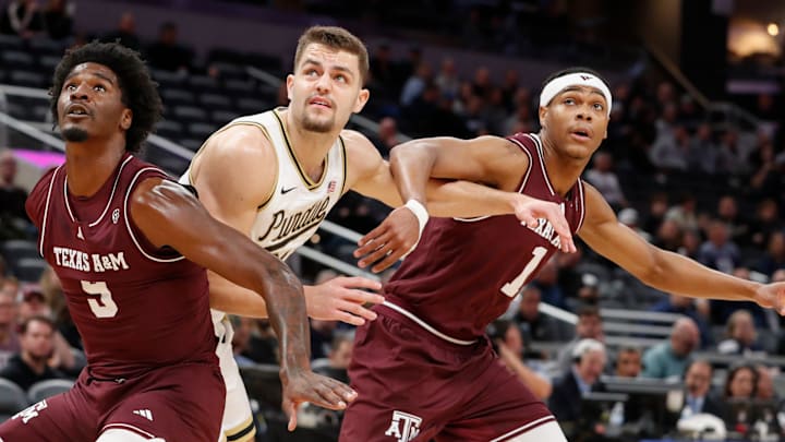Texas A&M Aggies forward Solomon Washington (9) and Texas A&M Aggies guard Zhuric Phelps (1) box out Purdue Boilermakers forward Camden Heide (23) Saturday, Dec. 14, 2024, during the NCAA men’s basketball game at Gainbridge Fieldhouse in Indianapolis.