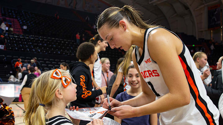 Oregon State's AJ Marotte (11), right, signs a poster for a young fan after an NCAA basketball game at Gill Coliseum on Thursday, Jan. 9, 2025, in Corvallis, Ore.
