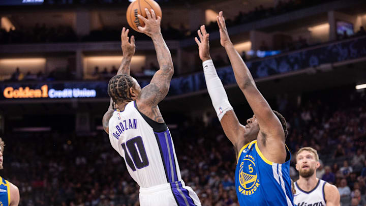 Oct 9, 2024; Sacramento, California, USA; Sacramento Kings forward DeMar DeRozan (10) passes the ball over Golden State Warriors forward Kevon Looney (5) during the first quarter at Golden 1 Center. Mandatory Credit: Ed Szczepanski-Imagn Images