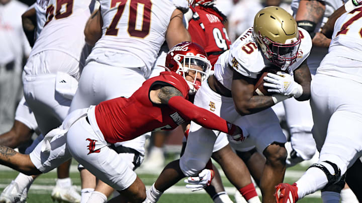 Sep 23, 2023; Louisville, Kentucky, USA;  Boston College Eagles running back Kye Robichaux (5) runs the ball against Louisville Cardinals defensive back Josh Minkins (5)  during the first quarter at L&N Federal Credit Union Stadium. Mandatory Credit: Jamie Rhodes-Imagn Images