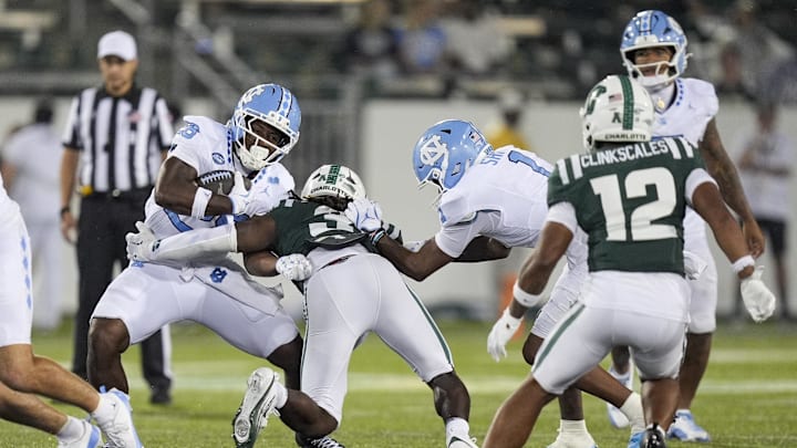 Sep 6, 2025; Charlotte, North Carolina, USA; North Carolina Tar Heels running back Jo Jo Troupe (26) is tackled by Charlotte 49ers defensive back Collin Gill (3) during the second half at Jerry Richardson Stadium. 