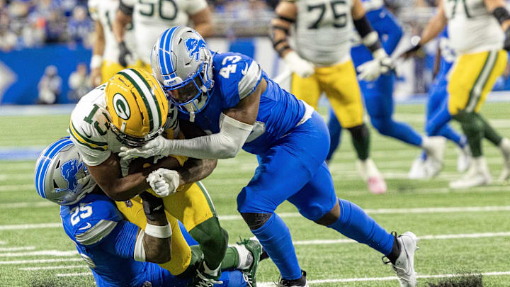 Dec 5, 2024; Detroit, Michigan, USA; Detroit Lions defensive back Jamal Adams (25) tackles Green Bay Packers wide receiver Dontayvion Wicks (13) with help from linebacker David Long Jr. (43) during the fourth quarter at Ford Field. Mandatory Credit: David Reginek-Imagn Images
