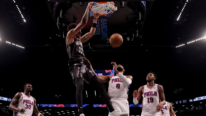 Feb 12, 2025; Brooklyn, New York, USA; Brooklyn Nets center Nic Claxton (33) dunks against Philadelphia 76ers center Adem Bona (30) and forwards Paul George (8) and Justin Edwards (19) and guard Quentin Grimes (5) during the fourth quarter at Barclays Center. Mandatory Credit: Brad Penner-Imagn Images