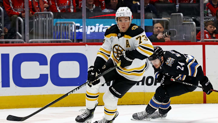Dec 31, 2024; Washington, District of Columbia, USA; Boston Bruins defenseman Charlie McAvoy (73) skates with the puck against Washington Capitals center Connor McMichael (24) at Capital One Arena. Mandatory Credit: Peter Casey-Imagn Images