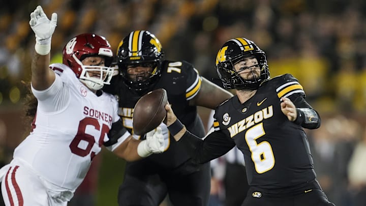 Nov 9, 2024; Columbia, Missouri, USA; Missouri Tigers quarterback Drew Pyne (6) throws a pass against Oklahoma Sooners defensive lineman Jayden Jackson (65) during the second half at Faurot Field at Memorial Stadium. Mandatory Credit: Jay Biggerstaff-Imagn Images