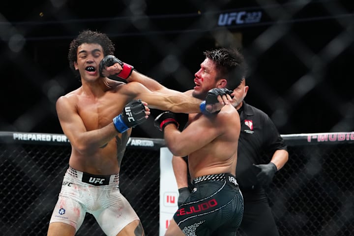 Henry Cejudo (red gloves) fights Payton Talbott (blue gloves) during UFC 323 at T-Mobile Arena.