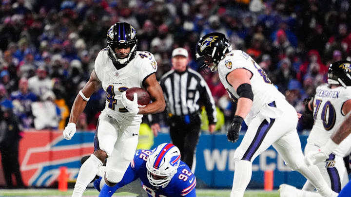 Jan 19, 2025; Orchard Park, New York, USA; Baltimore Ravens running back Justice Hill (43) runs the ball against Buffalo Bills defensive tackle DaQuan Jones (92) during the third quarter in a 2025 AFC divisional round game at Highmark Stadium. Mandatory Credit: Gregory Fisher-Imagn Images