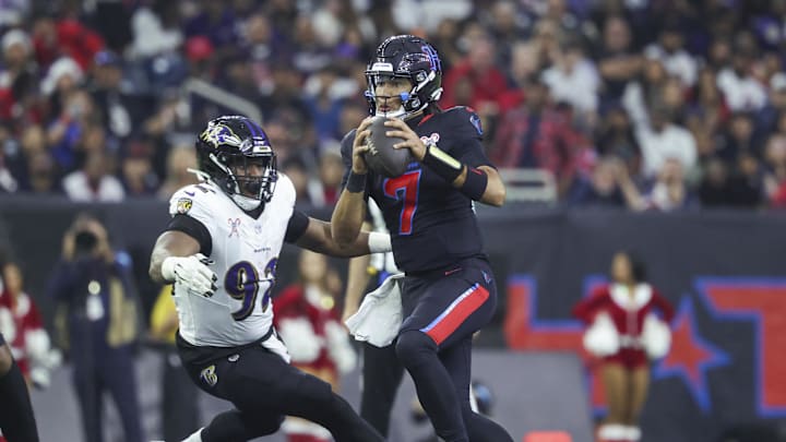 Dec 15, 2024; Houston, Texas, USA; Houston Texans quarterback C.J. Stroud (7) looks for an open receiver as Baltimore Ravens defensive tackle Nnamdi Madubuike (92) attempts to make a tackle during the second quarter at NRG Stadium. Mandatory Credit: Troy Taormina-Imagn Images