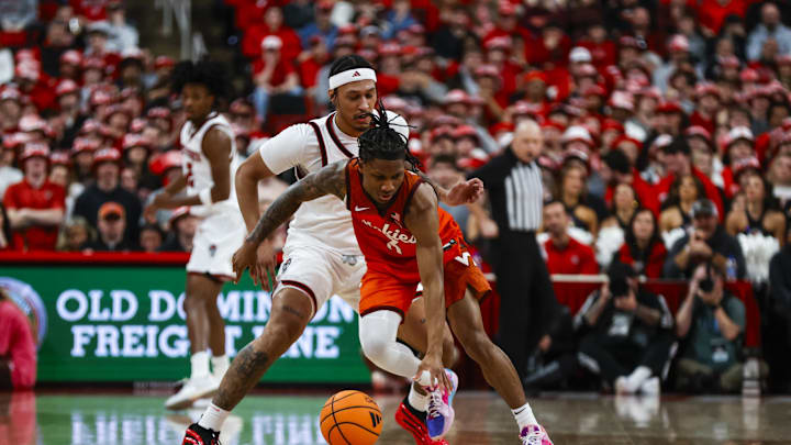Feb 7, 2026; Raleigh, North Carolina, USA; Virginia Tech Hokies guard Ben Hammond (3) dribbles with the ball guarded by NC State Wolfpack forward Darrion Williams (1) during the first half of the game at Lenovo Center. Mandatory Credit: Jaylynn Nash-Imagn Images