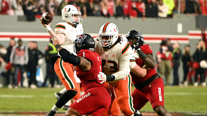 Nov 4, 2023; Raleigh, North Carolina, USA; Miami Hurricanes quarterback Tyler Van Dyke (9) throws a pass as he is pressured by North Carolina State Wolfpack defensive end Davin Vann (1) during the second half at Carter-Finley Stadium. Mandatory Credit: Rob Kinnan-Imagn Images Nov 4, 2023; Raleigh, North Carolina, USA; Miami Hurricanes quarterback Tyler Van Dyke (9) throws a pass as he is pressured by North Carolina State Wolfpack defensive end Davin Vann (1) during the second half at Carter-Finley Stadium. Mandatory Credit: Rob Kinnan-Imagn Images
