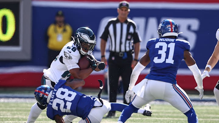 Oct 20, 2024; East Rutherford, New Jersey, USA; Philadelphia Eagles running back Saquon Barkley (26) is tackled by New York Giants cornerback Cor'Dale Flott (28) in front of safety Tyler Nubin (31) during the first half at MetLife Stadium.  