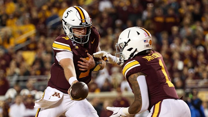 Oct 11, 2025; Minneapolis, Minnesota, USA; Minnesota Golden Gophers quarterback Drake Lindsey (5) hands the ball off to running back Darius Taylor (1) against the Purdue Boilermakers during the first half at Huntington Bank Stadium. Mandatory Credit: Matt Krohn-Imagn Images