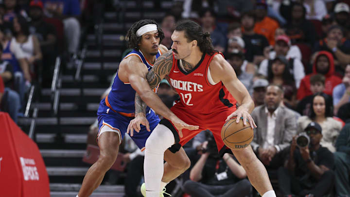 Nov 4, 2024; Houston, Texas, USA; Houston Rockets center Steven Adams (12) controls the ball as New York Knicks center Jericho Sims (20) defends during the second half at Toyota Center. Mandatory Credit: Troy Taormina-Imagn Images