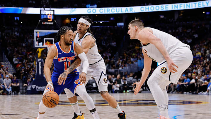 Mar 21, 2024; Denver, Colorado, USA; New York Knicks guard Jalen Brunson (11) controls the ball under pressure from Denver Nuggets forward Aaron Gordon (50) as center Nikola Jokic (15) defends in the third quarter at Ball Arena. Mandatory Credit: Isaiah J. Downing-Imagn Images