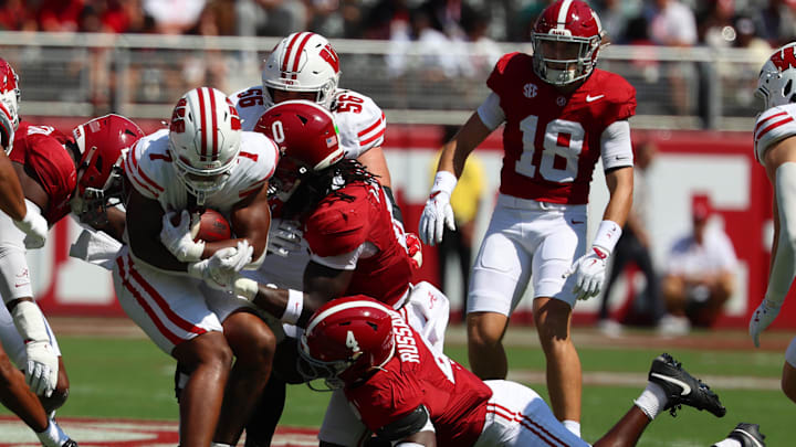 Sep 13, 2025; Tuscaloosa, Alabama, USA; Wisconsin Badgers running back Dilin Jones (7) is taken down by Alabama Crimson Tide linebacker Deontae Lawson (0) and Alabama Crimson Tide linebacker Qua Russaw (4) during the first quarter at Saban Field at Bryant-Denny Stadium. Mandatory Credit: David Leong-Imagn Images Sep 13, 2025; Tuscaloosa, Alabama, USA; Wisconsin Badgers running back Dilin Jones (7) is taken down by Alabama Crimson Tide linebacker Deontae Lawson (0) and Alabama Crimson Tide linebacker Qua Russaw (4) during the first quarter at Saban Field at Bryant-Denny Stadium. Mandatory Credit: David Leong-Imagn Images