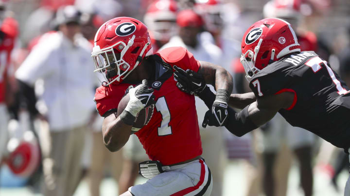 Apr 13, 2024; Athens, GA, USA; Georgia Bulldogs running back Trevor Etienne (1) gets tackled by defensive back Daniel Harris (7) during the G-Day Game at Sanford Stadium. Mandatory Credit: Mady Mertens-USA TODAY Sports