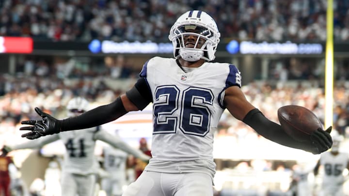 Oct 19, 2025; Arlington, Texas, USA; Dallas Cowboys cornerback Daron Bland (26) carries the ball after an interception for a touchdown against the Washington Commanders during the third quarter of the game at AT&T Stadium. Mandatory Credit: Kevin Jairaj-Imagn Images