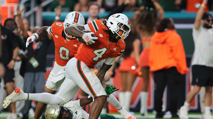 Sep 13, 2025; Miami Gardens, Florida, USA; Miami Hurricanes running back Mark Fletcher Jr. (4) carries the football for a touchdown against South Florida Bulls cornerback James Chenault (9) during the second quarter at Hard Rock Stadium. Mandatory Credit: Sam Navarro-Imagn Images