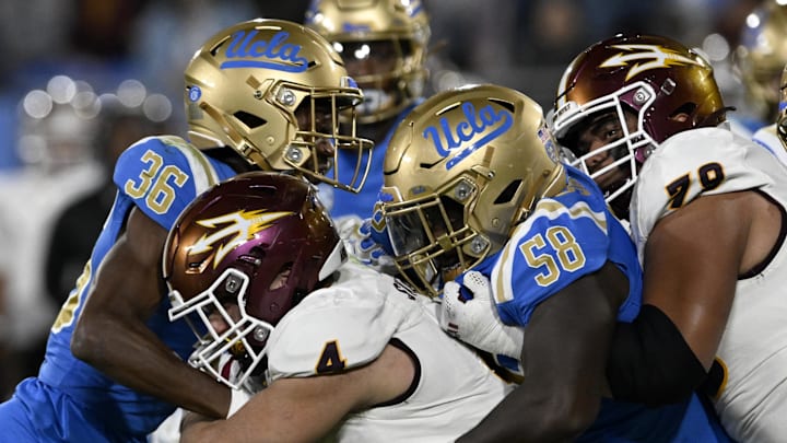 Nov 11, 2023; Pasadena, California, USA;  Arizona State Sun Devils running back Cameron Skattebo (4) runs against UCLA Bruins defensive back Alex Johnson (36) and defensive lineman Gary Smith III (58) during the second half at the Rose Bowl. Mandatory Credit: Alex Gallardo-Imagn Images