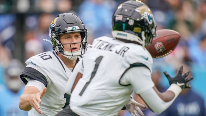 Jacksonville Jaguars quarterback Mac Jones (10) tosses the ball to running back Travis Etienne Jr. (1) during the first quarter at Nissan Stadium in Nashville, Tenn., Sunday, Dec. 8, 2024.