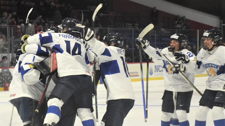 Members of the Finland team swarm goalie Sanni Ahola (left) after her final stop in a shootout against Czechia in the bronze medal game at the International Ice Hockey Federation Women's World Championship at the Adirondack Bank Center in Utica, New York, Sunday, April 14, 2024.
