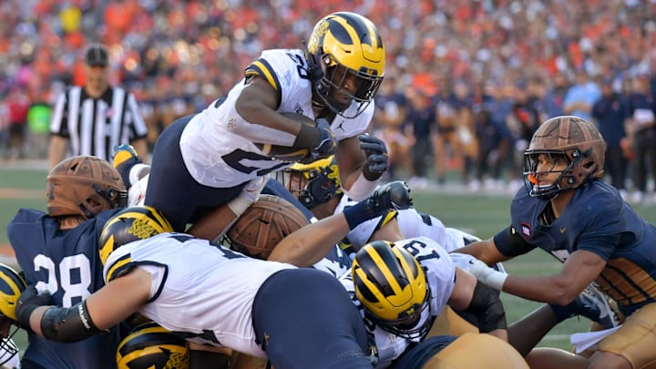 Oct 19, 2024; Champaign, Illinois, USA;  Michigan Wolverines running back Kalel Mullings (20) leaps over the line to score a touchdown against the Illinois Fighting Illini during the first half at Memorial Stadium. Mandatory Credit: Ron Johnson-Imagn Images