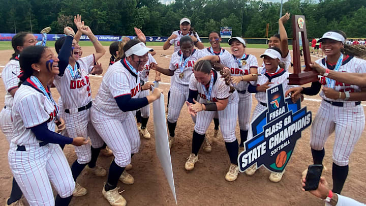 Doral Academy softball players celebrate after being awarded the FHSAA Class 6A state championship trophy on Saturday at Solider’s Creek Park.