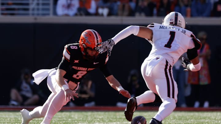 Oklahoma State's Maealiuaki Smith recovers before Texas Tech's A.J. McCarty can steal it during an NCAA football game on Saturday, Nov. 23, 2024, in Stillwater, Okla. Oklahoma State's Maealiuaki Smith recovers before Texas Tech's A.J. McCarty can steal it during an NCAA football game on Saturday, Nov. 23, 2024, in Stillwater, Okla.