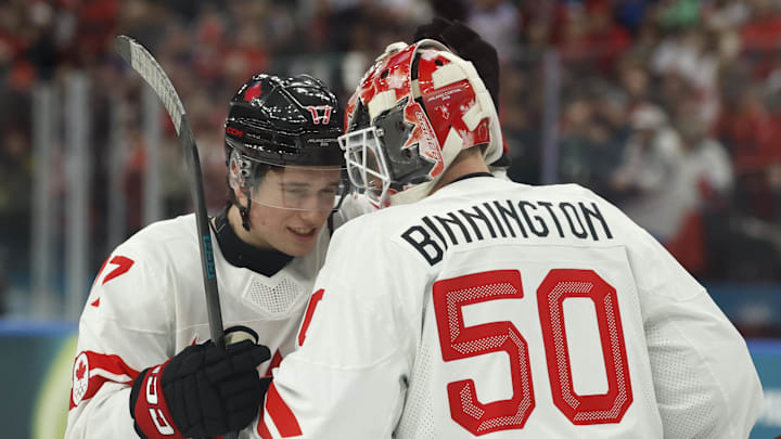Feb 12, 2026; Milan, Italy; Macklin Celebrini and Jordan Binnington of Canada celebrate after the match against Czechia in a men's ice hockey group A match during the Milano Cortina 2026 Olympic Winter Games at Milano Santagiulia Ice Hockey Arena. Mandatory Credit: Geoff Burke-Imagn Images