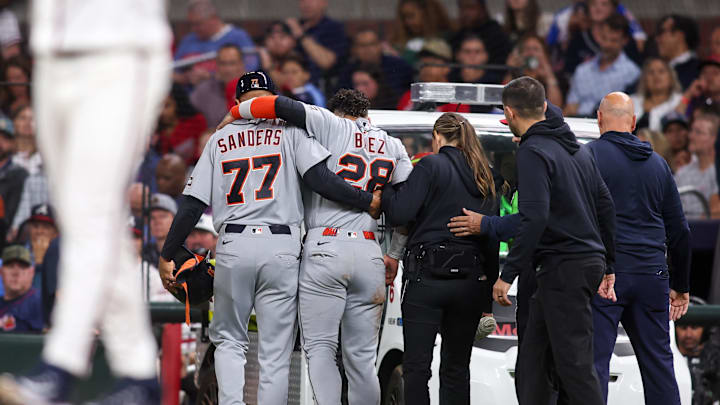 Detroit Tigers center fielder Javier Baez (28) is assisted by first base coach Anthony Sanders (77) after an injury against the Atlanta Braves in the fifth inning at Truist Park. Mandatory Credit: Brett Davis-Imagn Images