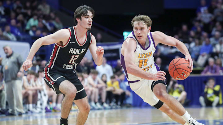 Lyon County's Travis Perry (11) drives on Harlan County's Caleb Johnson (12) Saturday at the 2024 UK