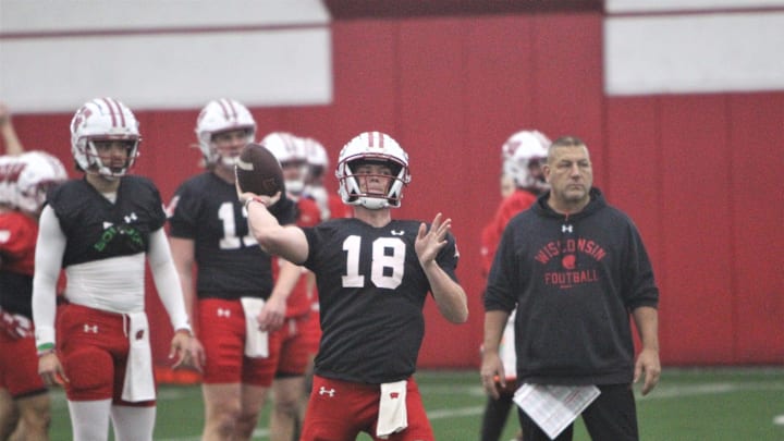 Wisconsin quarterback Braedyn Locke throws a pass as offensive coordinator Phil Longo watches during spring practice at the McClain Center in Madison, Wisconsin on Tuesday April 2, 2024.