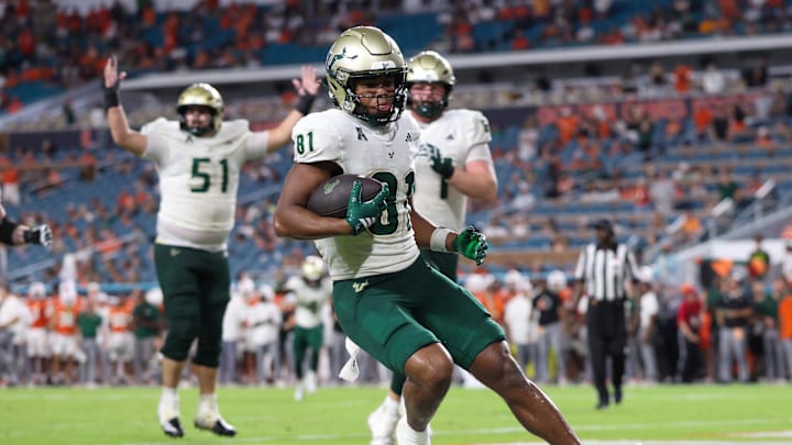 Sep 13, 2025; Miami Gardens, Florida, USA; South Florida Bulls wide receiver Christian Neptune (81) runs for a touchdown against the Miami Hurricanes in the fourth quarter at Hard Rock Stadium. Mandatory Credit: Nathan Ray Seebeck-Imagn Images