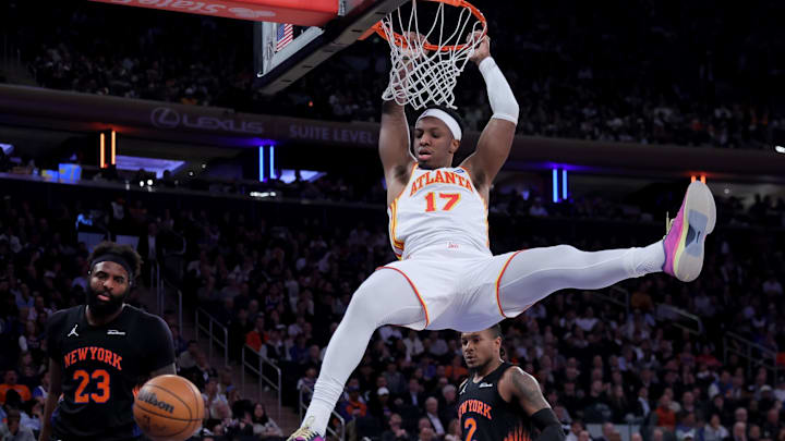 Apr 20, 2026; New York, New York, USA; Atlanta Hawks forward Onyeka Okongwu (17) hangs on the rim after a dunk against New York Knicks center Mitchell Robinson (23) and guard Miles McBride (2) during the third quarter of game two of the first round of the 2026 NBA Playoffs at Madison Square Garden. Mandatory Credit: Brad Penner-Imagn Images