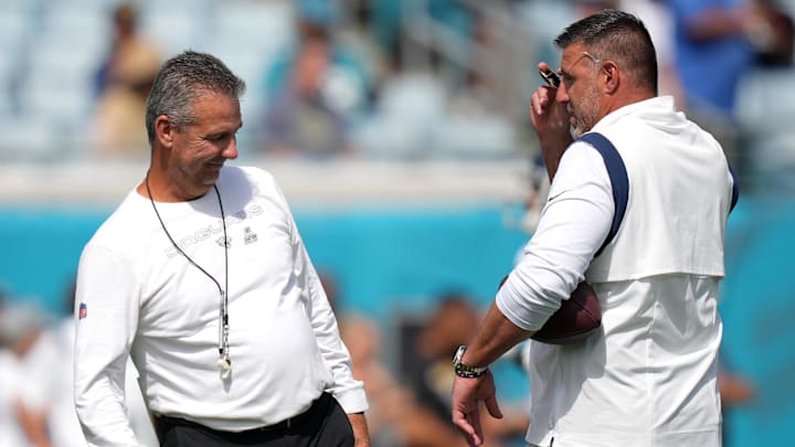 Oct 10, 2021; Jacksonville, Florida, USA; Jacksonville Jaguars head coach Urban Meyer (L) meets with Tennessee Titans head coach Mike Vrabel (R) prior to the game at TIAA Bank Field. Mandatory Credit: Jasen Vinlove-Imagn Images
