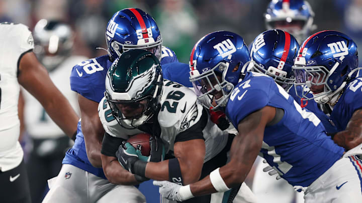 Oct 9, 2025; East Rutherford, New Jersey, USA; Philadelphia Eagles running back Saquon Barkley (26) carries the ball defended by New York Giants linebacker Bobby Okereke (58) and safety Tyler Nubin (27) during the first quarter of the game at MetLife Stadium.  