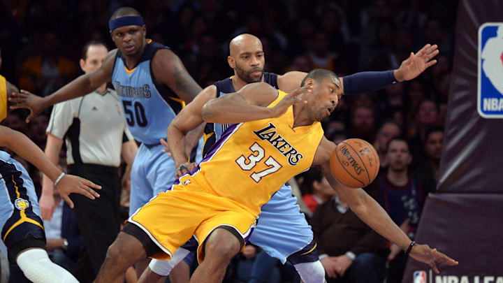 Mar 22, 2016; Los Angeles, CA, USA; Los Angeles Lakers forward Metta World Peace (37) aka Ron Artest is defended by Memphis Grizzlies guard Vince Carter (15) during an NBA game at Staples Center. The Lakers defeated the Grizzlies 107-100.  Mandatory Credit: Kirby Lee-Imagn Images