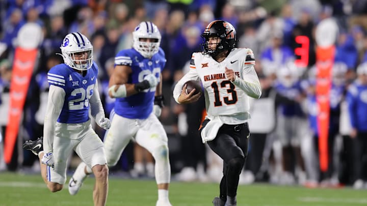 Oct 18, 2024; Provo, Utah, USA; Oklahoma State Cowboys quarterback Garret Rangel (13) runs from Brigham Young Cougars cornerback Jayden Dunlap (29) during the second quarter at LaVell Edwards Stadium. Mandatory Credit: Rob Gray-Imagn Images Oct 18, 2024; Provo, Utah, USA; Oklahoma State Cowboys quarterback Garret Rangel (13) runs from Brigham Young Cougars cornerback Jayden Dunlap (29) during the second quarter at LaVell Edwards Stadium. Mandatory Credit: Rob Gray-Imagn Images