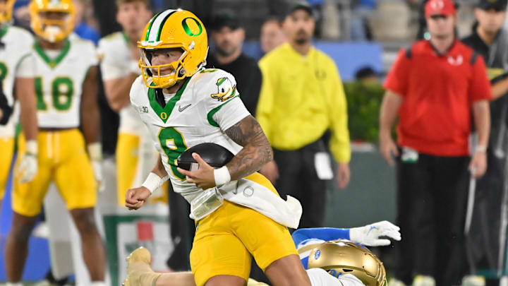 Sep 28, 2024; Pasadena, California, USA; Oregon Ducks quarterback Dillon Gabriel (8) runs past UCLA Bruins linebacker Carson Schwesinger (49) during the second quarter at Rose Bowl. Mandatory Credit: Robert Hanashiro-Imagn Images Sep 28, 2024; Pasadena, California, USA; Oregon Ducks quarterback Dillon Gabriel (8) runs past UCLA Bruins linebacker Carson Schwesinger (49) during the second quarter at Rose Bowl. Mandatory Credit: Robert Hanashiro-Imagn Images